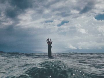 Man in the water desperately grasping for rescue